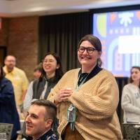 many people seated and standing